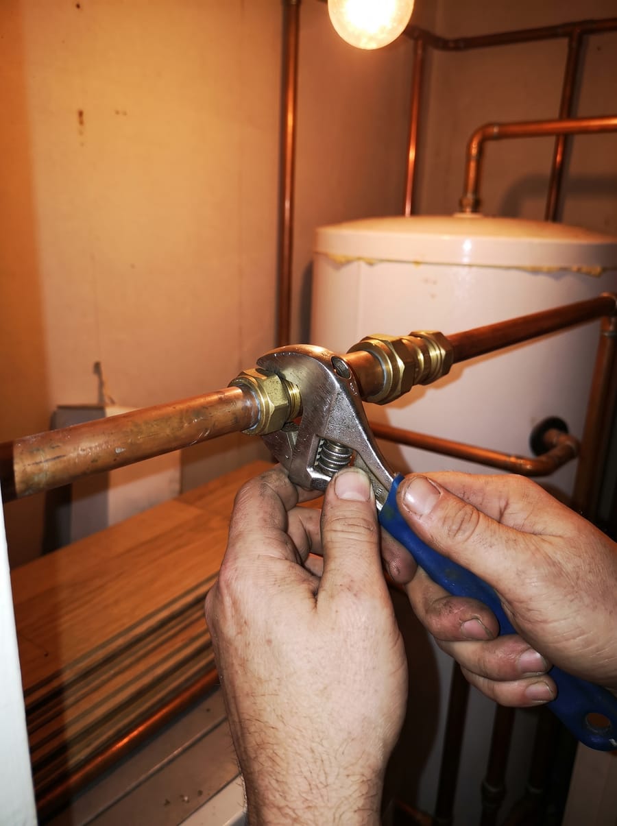 A compression fitting being tightened on copper pipework
